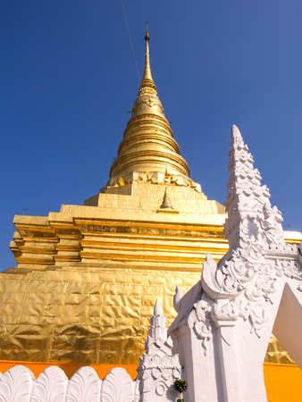 Northern Thai art Golden pagoda in Thailand under blue skyの写真素材