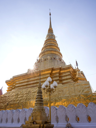 Northern Thai art Golden pagoda in Thailand under blue skyの写真素材