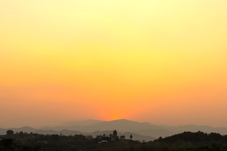 Sunset over mountain in Northern of Thailand under golden orange skyの写真素材