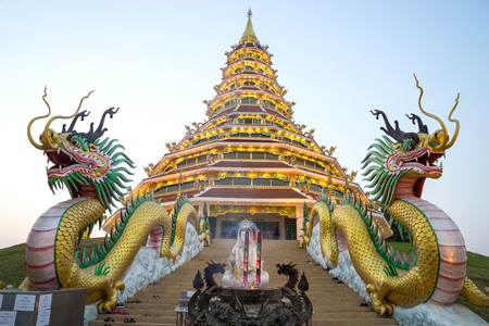 Chinese style nine level pagoda with dragon stairs in Thai temple under twilight skyの写真素材