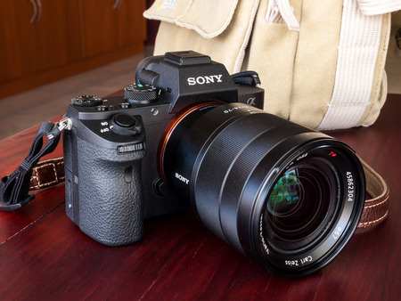 BANGKOK - FEBRUARY 19: Sony digital camera model A7II with normal Carl Zeiss zoom lens 24-70 mm f4 in natural light on red wooden table, was taken on February 19, 2015, in Bangkok Thailand.のeditorial素材