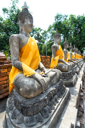 Old historic cement buddha statues along corridor of Thai temple in Ayuddhaya, Thailandの写真素材
