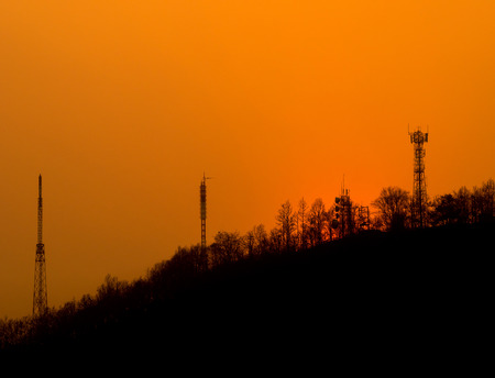 Sunset over urban mountain on orange evening skyの写真素材