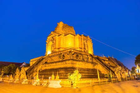 Ruined famous large buddhist Northern Thai art pagoda of Wat Jedi Luang in twilight evening period in Chiangmai, Thailandの写真素材