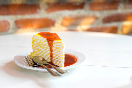 Strawberry crape cake on white dish lay on round table in bakery shopの写真素材