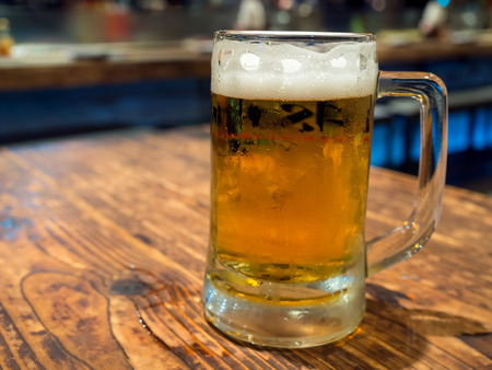 Beer with bubble level in glass on wooden table