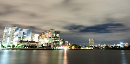 Buildings of Siriraj hospital, the first hospital in Thailand, along Chaophraya river, in twilight cloudy evening night light panoramic view, in Bangkok, Thailand.のeditorial素材