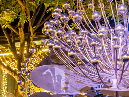 Modern art brittle fountain on pond under night sky, selective focus on some partの写真素材