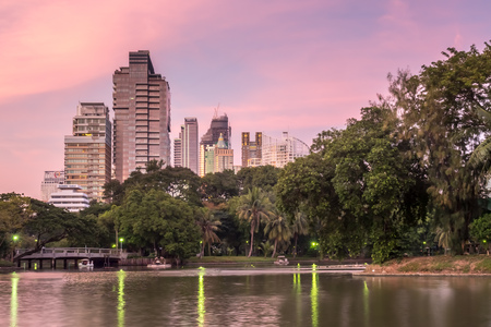 BANGKOK - DECEMBER 18: Skyscraper building cityscape with reflection on lake in park in Bangkok, Thailand, in evening twilight sky, was taken on December 18, 2015.のeditorial素材