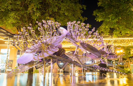 Modern art brittle fountain on pond under night skyの写真素材