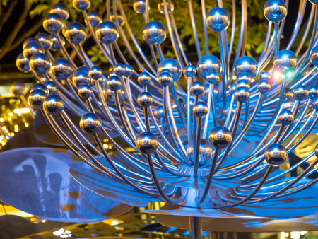Modern art brittle fountain on pond under night sky, selective focus on some partの写真素材