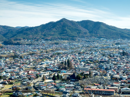 Mountain with cityscape view under blue sky in Japanの写真素材