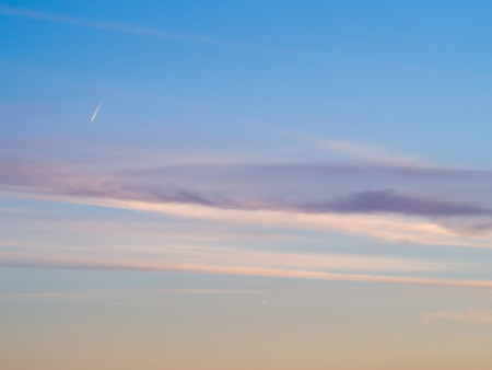 Cloud and jet contrail with blue sky backgroundの写真素材