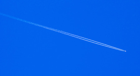 Cloud and jet contrail with blue sky backgroundの写真素材