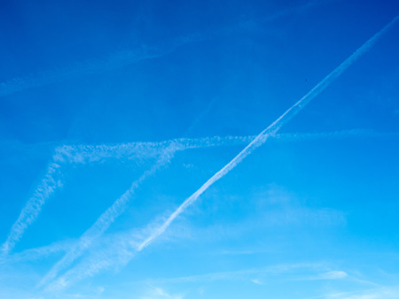 Cloud and jet contrail with blue sky backgroundの写真素材