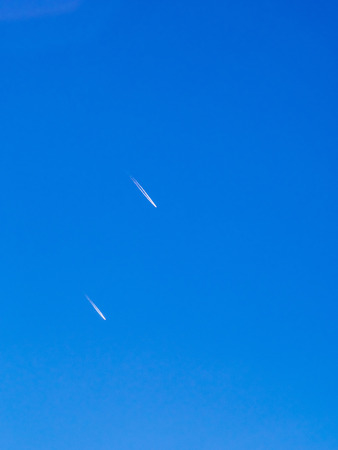 Cloud and jet contrail with blue sky backgroundの写真素材