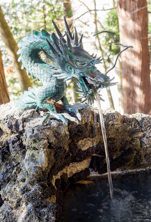 Well and dippers with dragon sculpture for wash hand and mouth, front of Japan temple, for respect and clean before walk to templeの写真素材