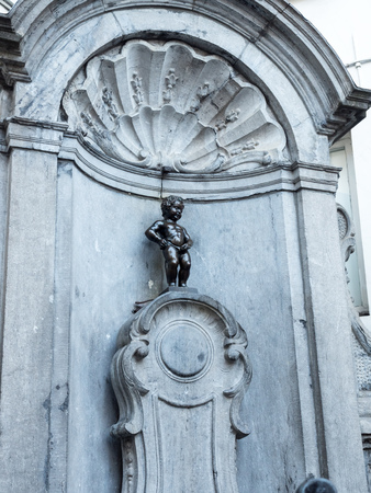 The small ,61 cm tall,  bronze statue on the corner of Rue de l'Etuve and Rue des Grands, known as "Manneken Pis" is symbol of Brussels in Belgiumのeditorial素材