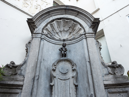 The small ,61 cm tall,  bronze statue on the corner of Rue de l'Etuve and Rue des Grands, known as "Manneken Pis" is symbol of Brussels in Belgiumのeditorial素材