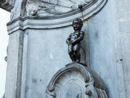 The small ,61 cm tall,  bronze statue on the corner of Rue de l'Etuve and Rue des Grands, known as "Manneken Pis" is symbol of Brussels in Belgiumのeditorial素材