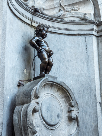 The small ,61 cm tall,  bronze statue on the corner of Rue de l'Etuve and Rue des Grands, known as "Manneken Pis" is symbol of Brussels in Belgiumのeditorial素材