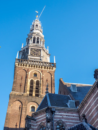 Top of the Old Church (Oude Kerk) in main red light district in Amsterdam, Netherlands, under blue skyの写真素材