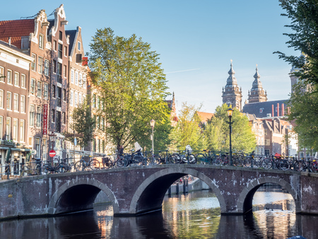 City scene in Amsterdam along canal under blue skyの写真素材