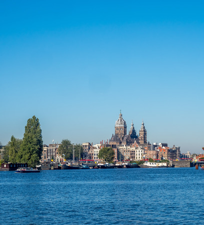 AMSTERDAM - OCTOBER 2: Saint Nicholas church with surrounding buildings with wide angle view under blue sky in Amsterdam, Netherlands, on October 2, 2015.のeditorial素材