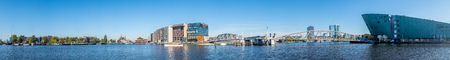 AMSTERDAM - OCTOBER 2: Panoramic view of architecture design buildings around pier near train...