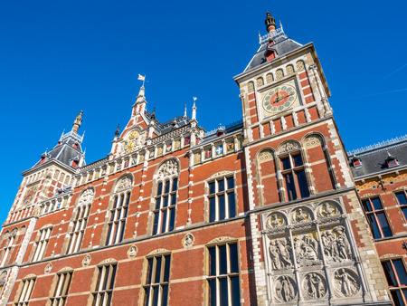 Outstanding beautiful architecture of Amsterdam train station building under blue sky, Netherlandsの写真素材
