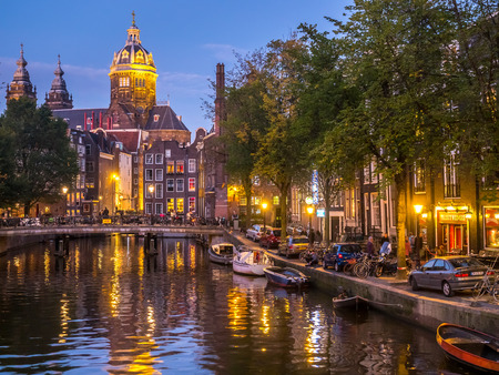 AMSTERDAM - OCTOBER 2: Saint Nicholas church from bridge at Red-light district under twilight evening sky in Amsterdam, Netherlands, on October 2, 2015.のeditorial素材