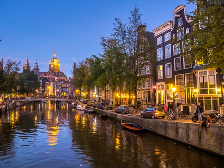 AMSTERDAM - OCTOBER 2: Saint Nicholas church from bridge at Red-light district under twilight evening sky in Amsterdam, Netherlands, on October 2, 2015.のeditorial素材
