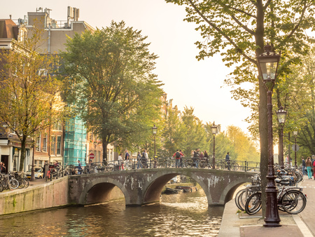 AMSTERDAM - OCTOBER 4: Amsterdam city scene along canal, the city of bicycle, in Netherlands, under evening natural light, on October 4, 2015.のeditorial素材