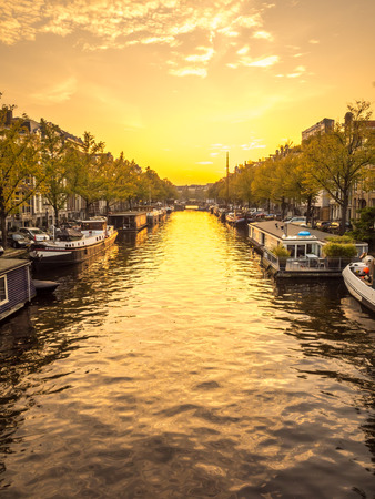 AMSTERDAM - OCTOBER 3: City scene of Amsterdam in evening twilight time along canal, bride and bicycles, Netherlands, on October 3, 2015.のeditorial素材