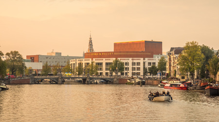 AMSTERDAM - OCTOBER 3: City scene of Amsterdam in evening twilight time along canal, bride and bicycles, Netherlands, on October 3, 2015.のeditorial素材