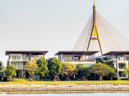 Huge bridge name Bhumiphol bridges cross Chaophraya river in Bangkok under white cloudy sky in evening twilight period / Thai letters is name of the bridge.のeditorial素材