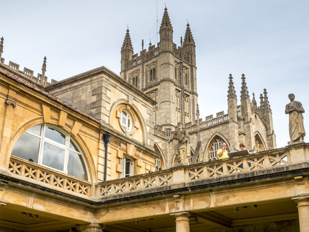BATH - MAY 19 : Roman Bath, the UNESCO World Heritage site, with The Bath Abbey behind under cloudy skyのeditorial素材