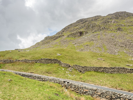 Countryside landscape view of grass above mountain under cloudy evening sky in rural Englandの写真素材