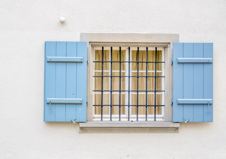 Blue opened window with white wallの写真素材