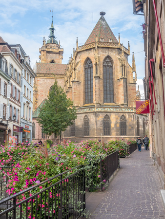 COLMAR - OCTOBER 9: Road to Saint Martin church with colorful flowers under cloudy sky in Colmar, France, on October 9, 2016.のeditorial素材