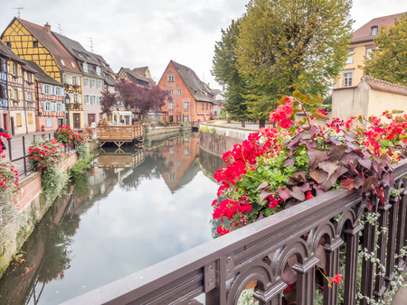 COLMAR - OCTOBER 9: Unique peaceful town and buildings in Colmar, known as little Venice, with colorful flowers along canal under cloudy sky in France, on October 9, 2016.のeditorial素材