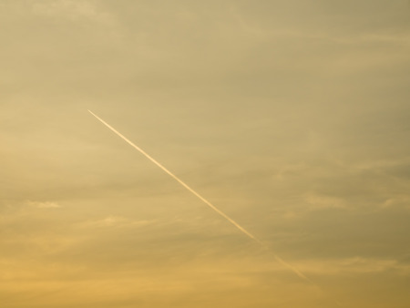 Aircraft contrail with golden twilight sky background
