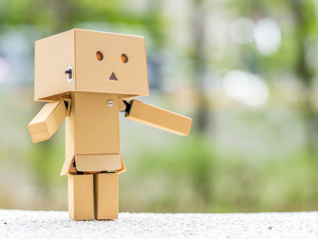 Extend the arms wait for hug action of cute box doll standing at outdoor park with natural light, selective focus at its eyeの写真素材