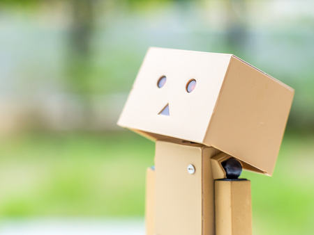 Look up to the sky action  of cute box doll standing at outdoor park with natural light, selective focus at its eyeの写真素材