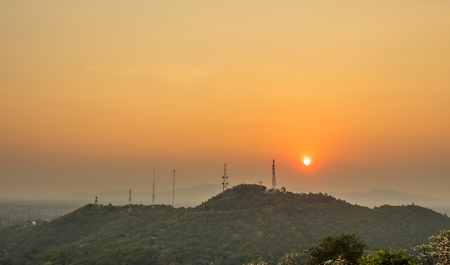 Sunset over green mountain under golden twilight skyの写真素材