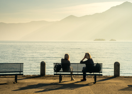 Lake Maggiore side scene with unrecognized people relax on bench in Locarno, Switzerlandの写真素材