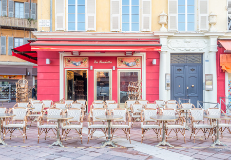 NICE - APRIL 9 : Chairs at front of coffee shop and restaurant on local road in Nice, France, on April 9, 2017.のeditorial素材