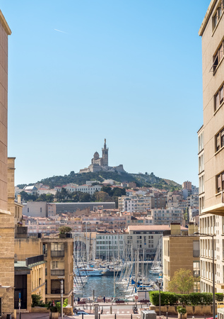 View of old port of Marseille and Basilica of Our Lady of Guard catholic church (Notre-Dame de la Garde) from street to the port in Marseille, Franceの写真素材