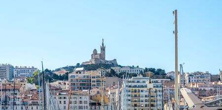 View of Basilica of Our Lady of the Guard catholic church (Notre-Dame de la guard) from old port of Marseille under clear blue skyの写真素材