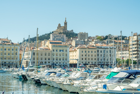 MARSEILLE - APRIL 11 : Old port of Marseille with Basilica of Our Lady of the Guard catholic church in background, crowded with luxury yachts, in Marseille, France, on April 11, 2017.のeditorial素材